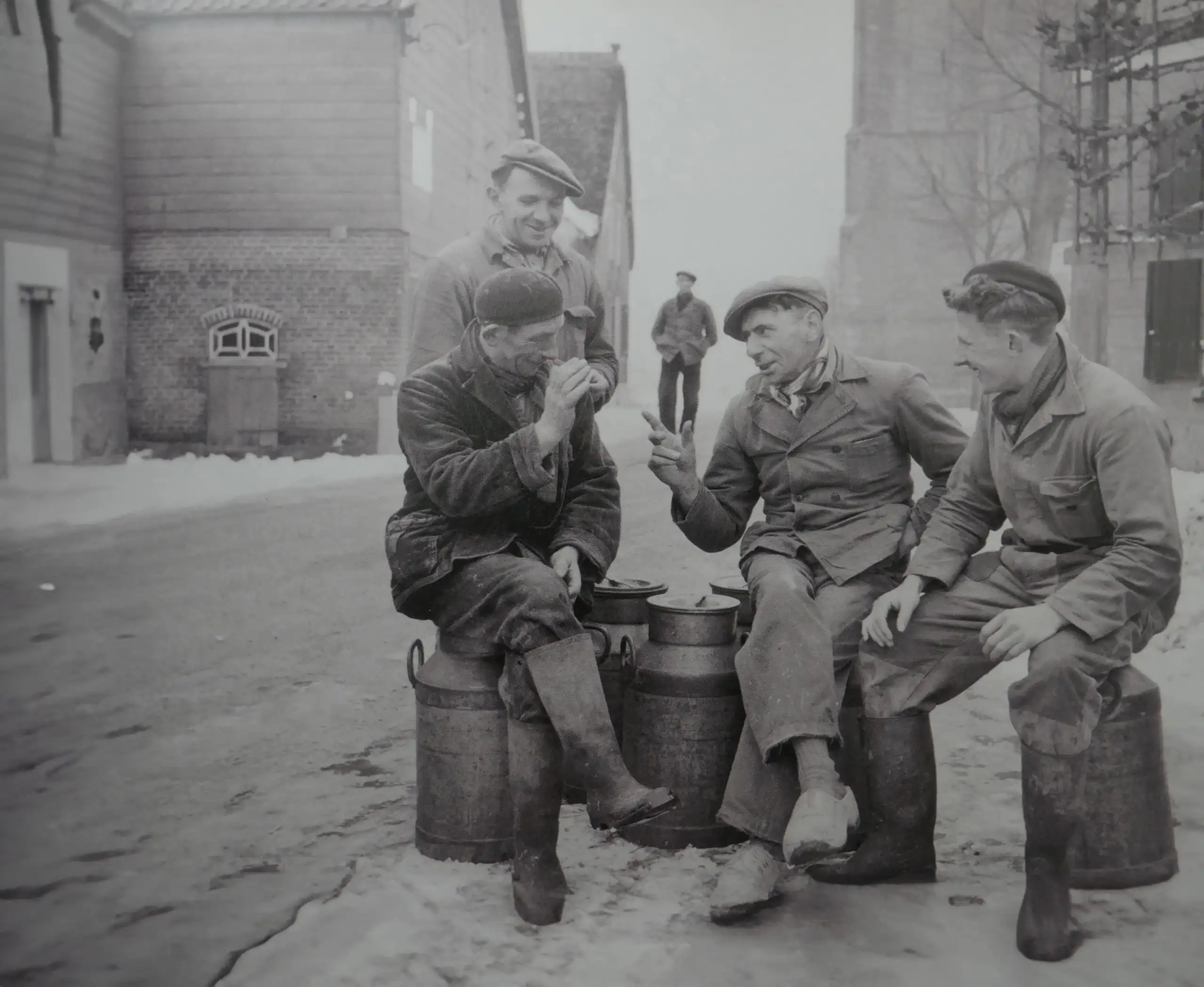 Zwart wit foto van 4 mannen die een praatje maken op een Landbouwdag in het verleden